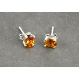 A pair of orange tourmaline ear studs, the oval cut stones claw set in silver, 1gm