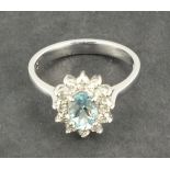 An aquamarine and diamond set dress ring, central oval cut  stone approx. 0.80ct, in an 18ct white