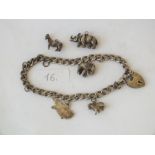 Silver charm bracelet and three loose charms 34g.