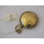 A Victorian circular locket, the hinged front revealing a glazed hair panel