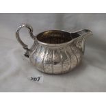 Victorian milk jug, the circular compressed body with fluted sides, 6” over leaf cup handle, Lon