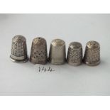Four silver thimbles and a metal one