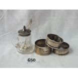 Pair of napkin rings, another and a glass mounted mustard pot with spoon