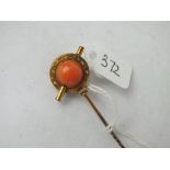 A good coral and cabochon garnet stick pin