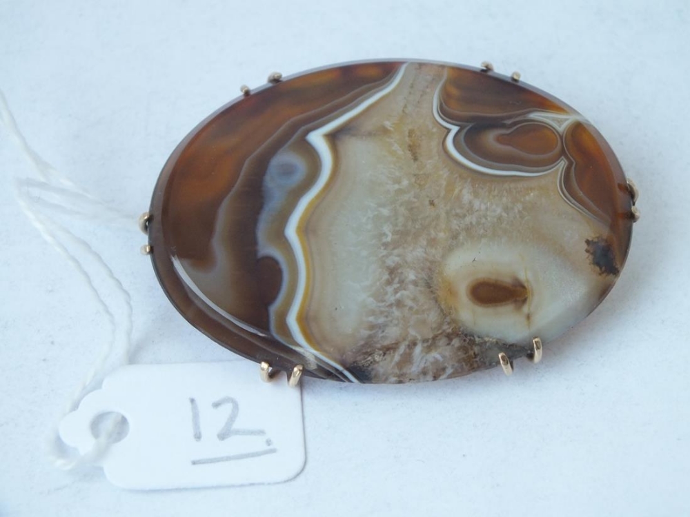 A oval gold mounted polished agate brooch