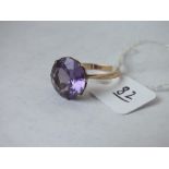 A purple stone solitaire ring set in 14ct, size R