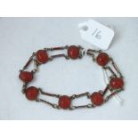 An unusual carved stone and enamel decorated link bracelet set in silver