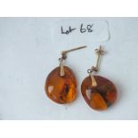 A pair of gold mounted and amber ear pendants