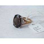 A smoky quartz ring with diamond shoulders set in 9ct. Size M