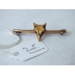 A gold fox head brooch with gem set shiny eyes