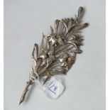A large white metal spray brooch