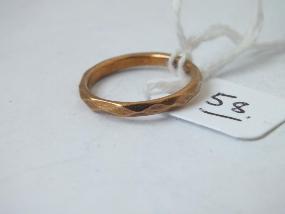 A 22ct gold wedding band with faceted decoration, 2.8g size J