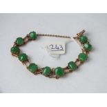 A jade bracelet set with eleven oval stones in 18ct gold