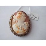 An oval carved shell cameo brooch of lady with flowers set in 9ct