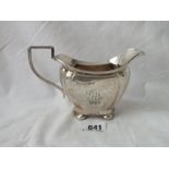 A shaped oval cream jug on bung feet 6” over handle 1922, 140g