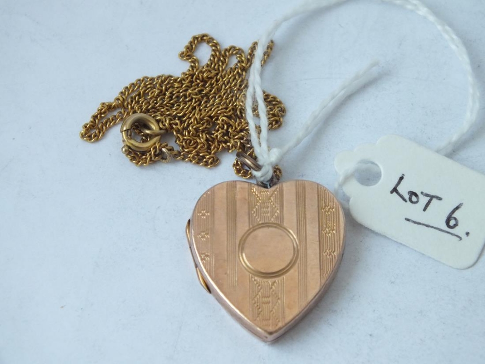 A 9ct back and front heart shaped hinged locket on a gilt neck chain