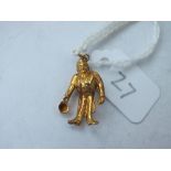 A gold figure charm holding top hat