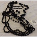 FOUR STRINGS OF BLACK GLASS BEADS