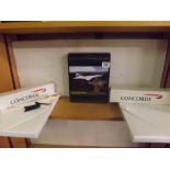 A SHELF WITH CONORD MEMORABILIA INCL; A WENTWORTH WOODEN JIGSAW OF CONCORD, TWO INVITATION PACKS &