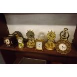 SHELF OF EIGHT VARIOUS BATTERY OPERATED CLOCKS