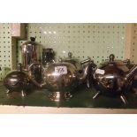 SHELF OF PLATED TEA POTS, COFFEE POT ETC