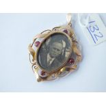 A garnet mounted oval photo locket/pendant in 9ct - 5.6gms