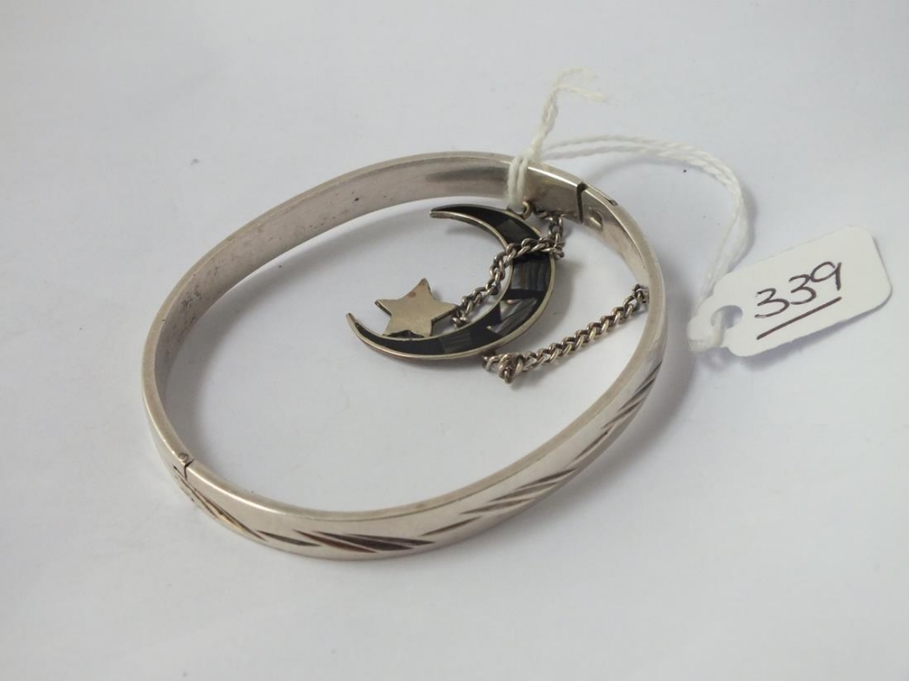 A white metal bangle together with a silver crescent pendant