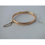 A HAMMERED EFFECT BANGLE IN 15CT GOLD - 10.1GMS