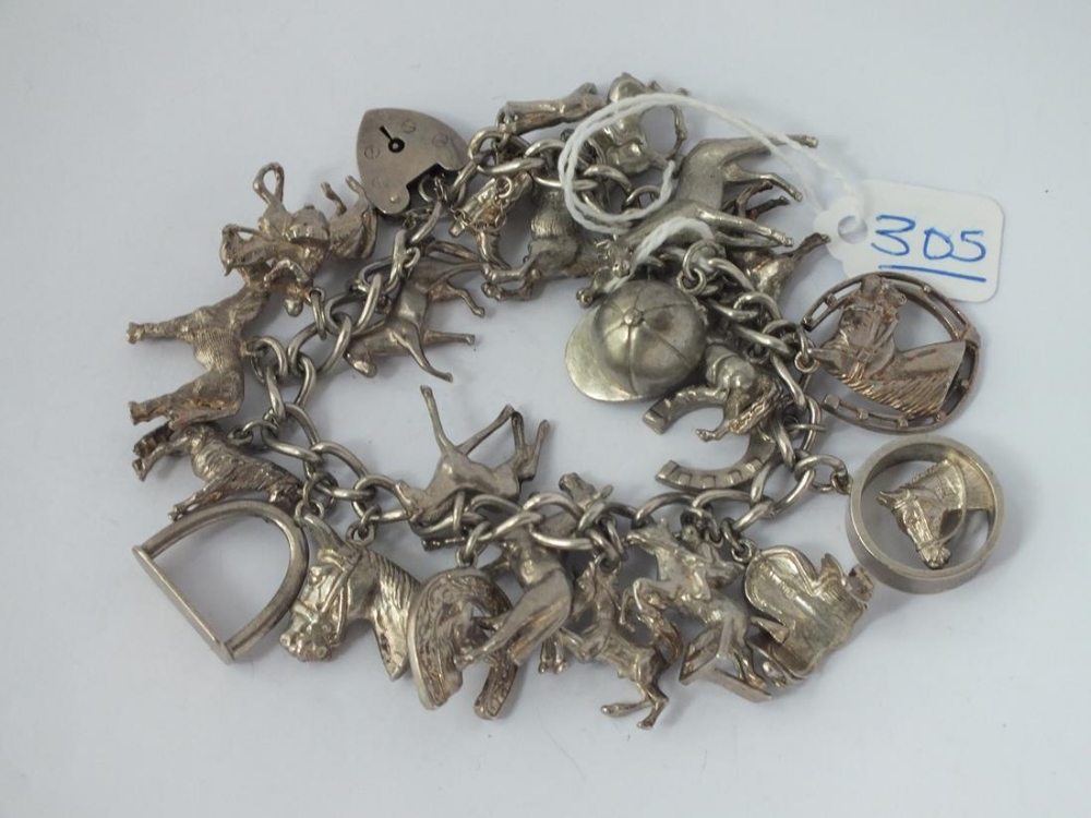 A silver heavy charm bracelet depicting horses, horseshoes etc. - 102gms