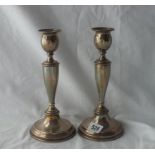 A pair of candle sticks with baluster shaped stems - circular bases - possibly London 1949 - 9" high