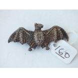 A silver brooch in the form of a flying bat