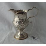 A George III embossed cream jug with lead inset base - 4" high