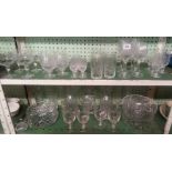 TWO SHELVES OF CUT GLASS DECANTERS, FRUIT BOWLS, WINE GLASSES ETC