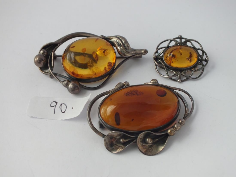 Three silver and amber brooches