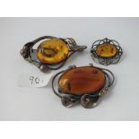Three silver and amber brooches