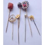 Seven assorted stick pins, garnet cluster, coral, star, horseshoe and three others