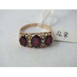 Three-stone garnet and gem set ring in 9ct - size U