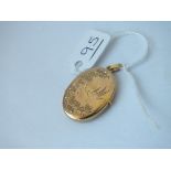 A oval engraved locket in 9ct - 3.6gms