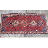 A red ground rug with pale medallion - 6'3" x 2'8"