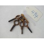 A small gold watch key together with 4 other metal watch keys
