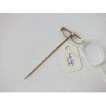 A pearl mounted riding crop stick pin in 15ct gold