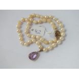 A pearl necklace with 9ct amethyst drop & fan shaped 9ct clasp