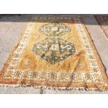 A orange coloured rug with 2 madellions - 9' x 6'