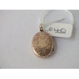 An oval Victorian back & front locket with floral engrave decoration - 3.2gms - 23 x 18mm set in