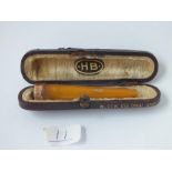 A cased cheroot holder with 9ct mount
