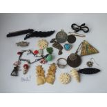 An interesting bag of carved bone items, assorted brooches, medallion etc.