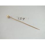 An antique stick pin with natural pearl terminal in 15ct gold