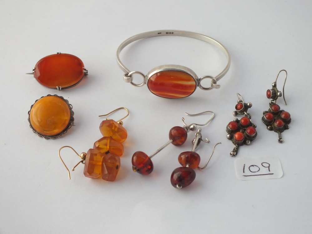 A bag of assorted silver cornelian & amber bracelets, brooches etc.