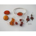 A bag of assorted silver cornelian & amber bracelets, brooches etc.
