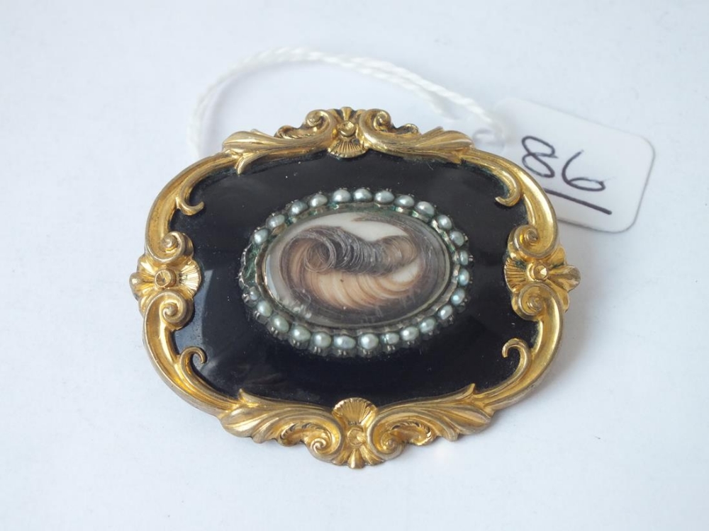 A large antique black enamel, pearl & hair set mourning brooch